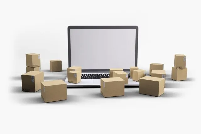Pachete și un laptop pe o masă, în timp ce cineva comandă online înainte de sărbători