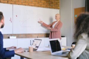 Contract comercial pe o masă de lemn, cu un stilou pregătit pentru semnare și ochelari alături