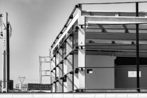 Șantier de construcție pentru o hală industrială, cu structură metalică și utilaje la lucru